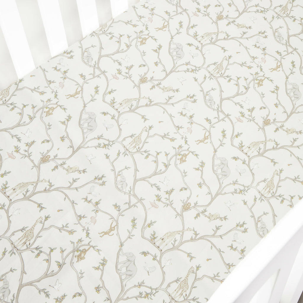Animal Parade Print in Ivory in a crib