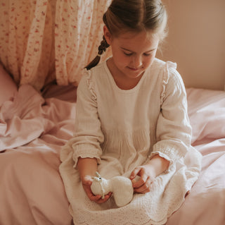 Scalloped Starlight Toddler Duvet in Rose with Toddler sitting on bed