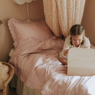 Scalloped Starlight Twin Duvet Set in Rose with little girl on bed playing.