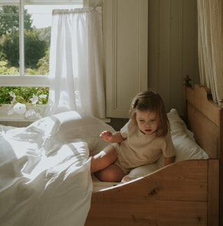 Scalloped Starlight Toddler Duvet in White with child in bed