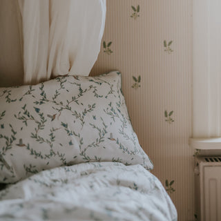 Secret Garden Standard Pillowcase Set Print in the Color Ivory on a bed