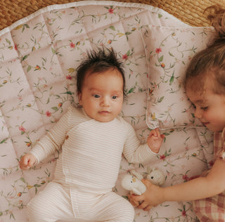 Dreaming of Paradise Playmat with baby and little girl laying on top playing
