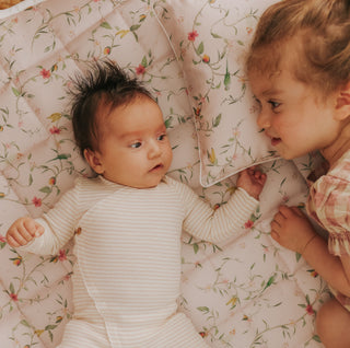 Dreaming of Paradise Playmat with baby and little girl laying on top playing