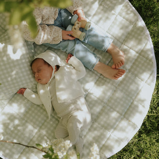 Picnic Gingham Green Playmat with a baby sleeping and toddler playing