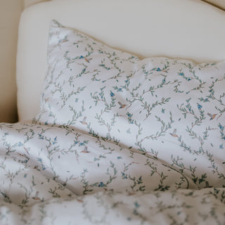 Toddler Duvet and Toddler Pillow in a bed in the "Secret Garden" print in Ivory