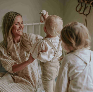 Mom sitting on bed with kids
