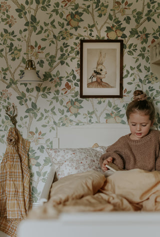 A girl sitting in toddler bed