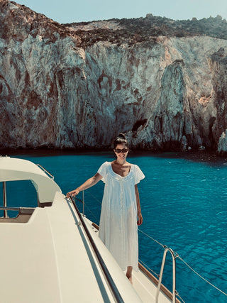 A lady in white dress on a boat in Greece 