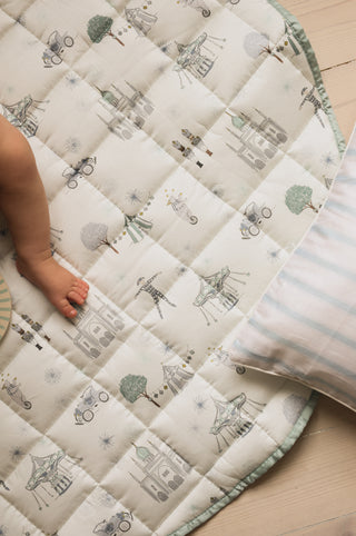 playmat in the adventures in wonderland print in aqua with a baby on it 