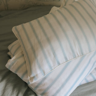 Seaside Stripe Pillow laying on top of a bed