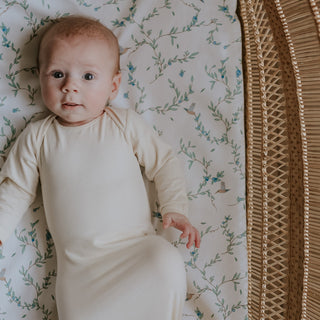 Baby laying on top of patterned crib sheet