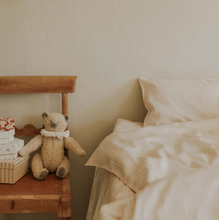 beddig with a chair and teddy bear