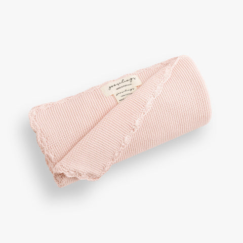 Cotton Knit Baby Blanket in Pink rolled up. The Gooselings label is shown for detail