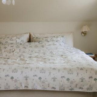 Adventures in Wonderland Full/Queen Duvet Cover in the Aqua Print displayed on bed. Shown with two standard size pillow cases in the same print.