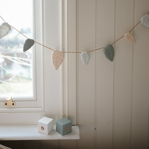 Secret Garden Garland hanging across window with toy blocks on windowsill