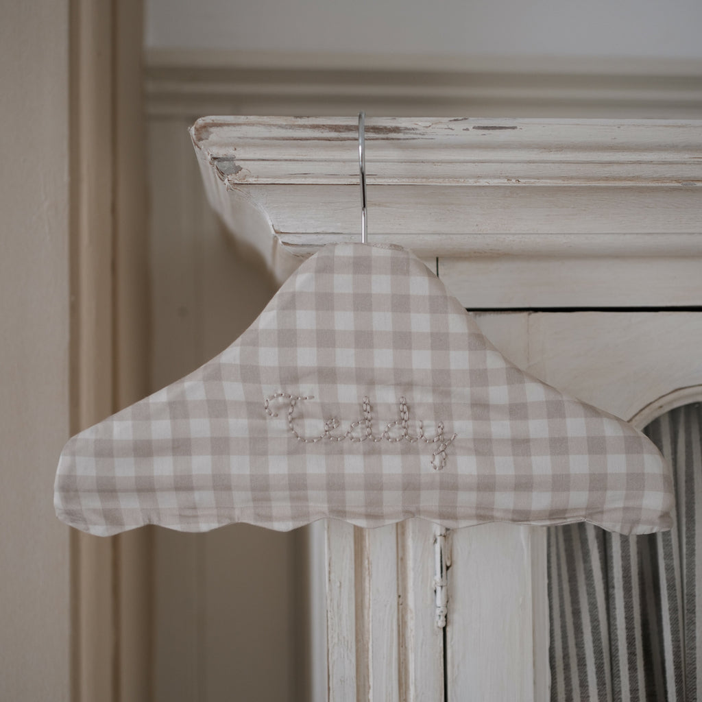 Children's Hanger in Beige Gingham hanging off top of armoire