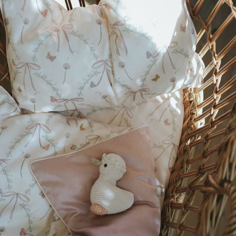 Bows & Butterfly Kisses print showing pink backside. Goosie stuffy laying on top.