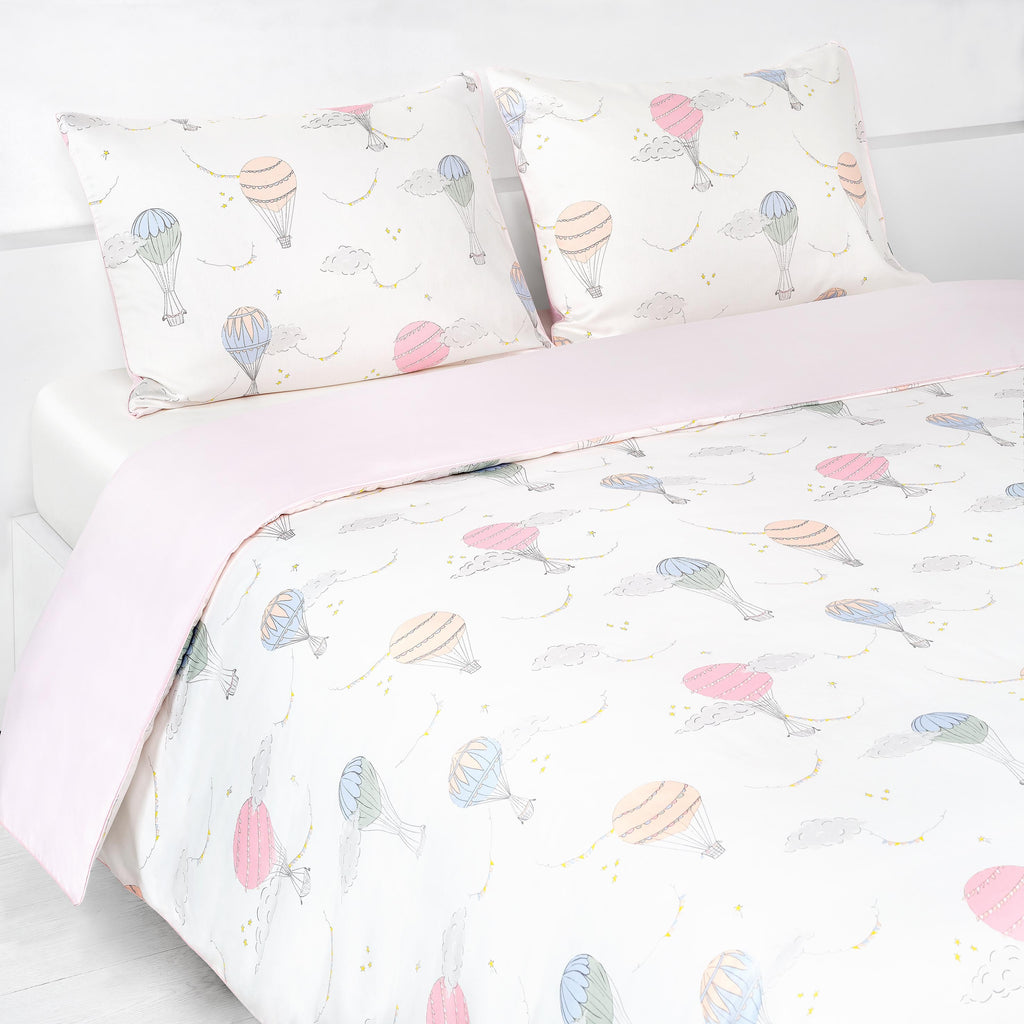 Touch The Sky Full/Queen Duvet Cover in the Pink Print displayed on bed. Shown with two standard size pillow cases in the same print.