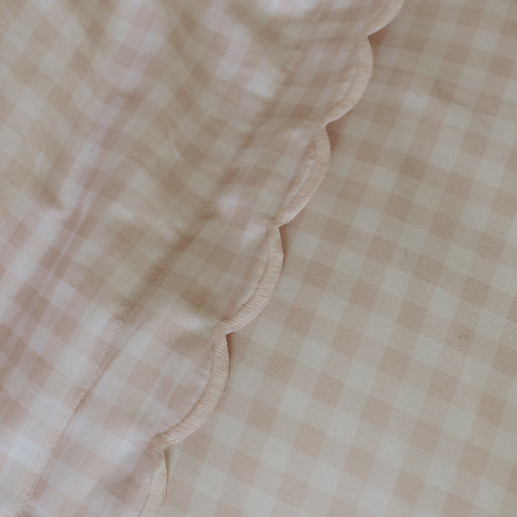 Detail picture of the scallop treatment on the pillow on picnic ginham