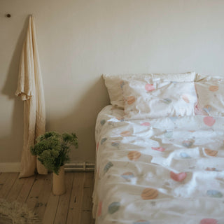 Touch The Sky Print In Pink, on a full size bed