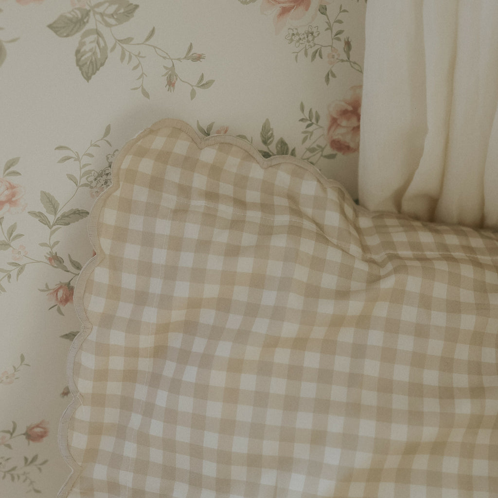 Picnic Gingham Twin Set in Beige. Pillow in bedroom with floral wallpaper