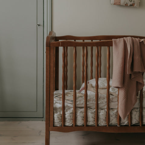 Animal Parade Crib Sheet in Ivory. Crib in room with  Baby Duvet, Crib Sheet and Pillow inside. Blanket hanging over crib.