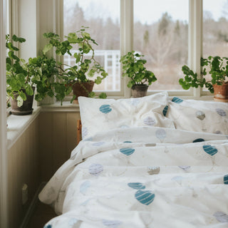 Touch The Sky Full/Queen Duvet Cover in the Blue Print displayed on bed. Shown with two standard size pillow cases in the same print.