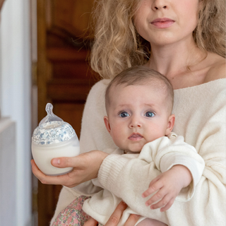 Woman holding a baby and a decorative baby  bottle