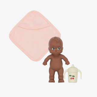 Toy baby figure with a pink blanket and sippy cup on a white background