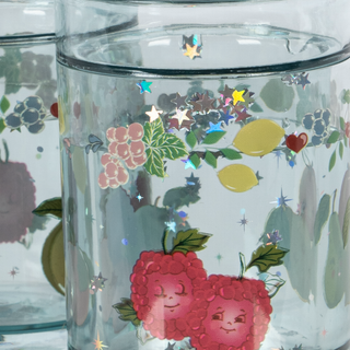 Clear tumbler with colorful fruit and floral designs on a white background