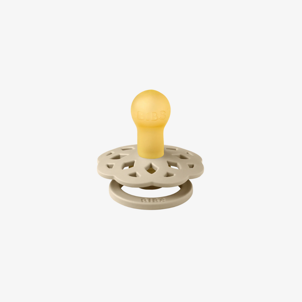 Baby teether with yellow top and beige base on a white background