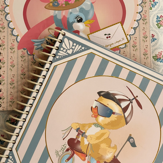 Notebook with a decorative cover featuring a cartoon duck on a bicycle.