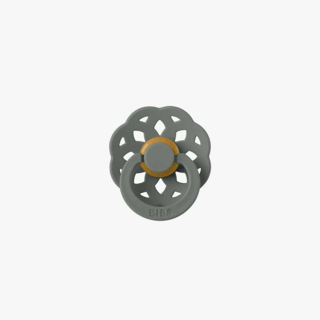 green floral-shaped pacifier with a gold center on a white background