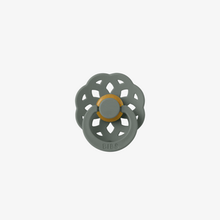 green floral-shaped pacifier with a gold center on a white background