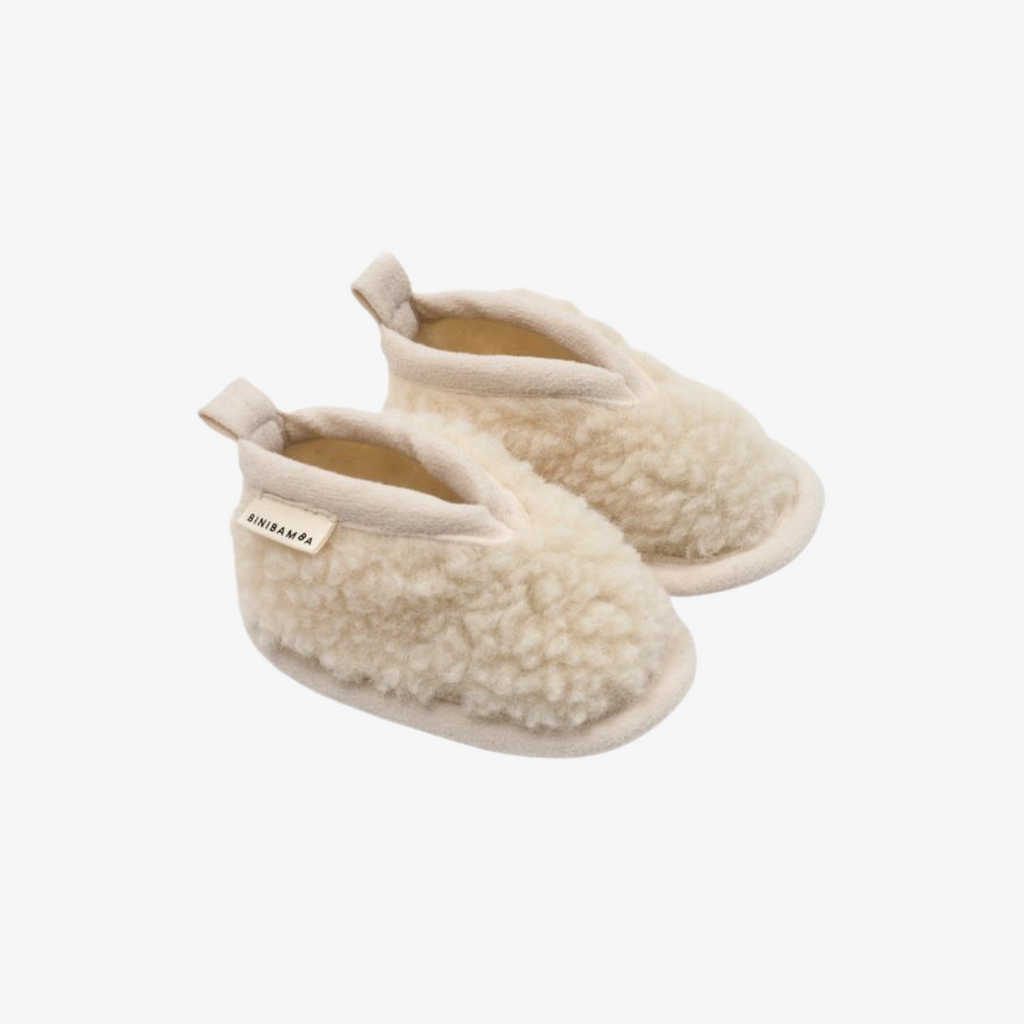 Pair of beige slippers on a white background