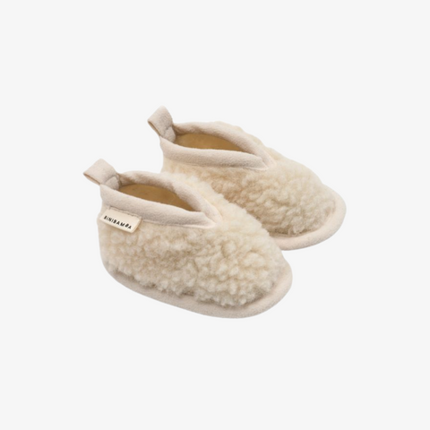 Pair of beige slippers on a white background