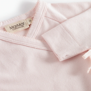Close-up of a pink baby garment with a MarMar label on a white background