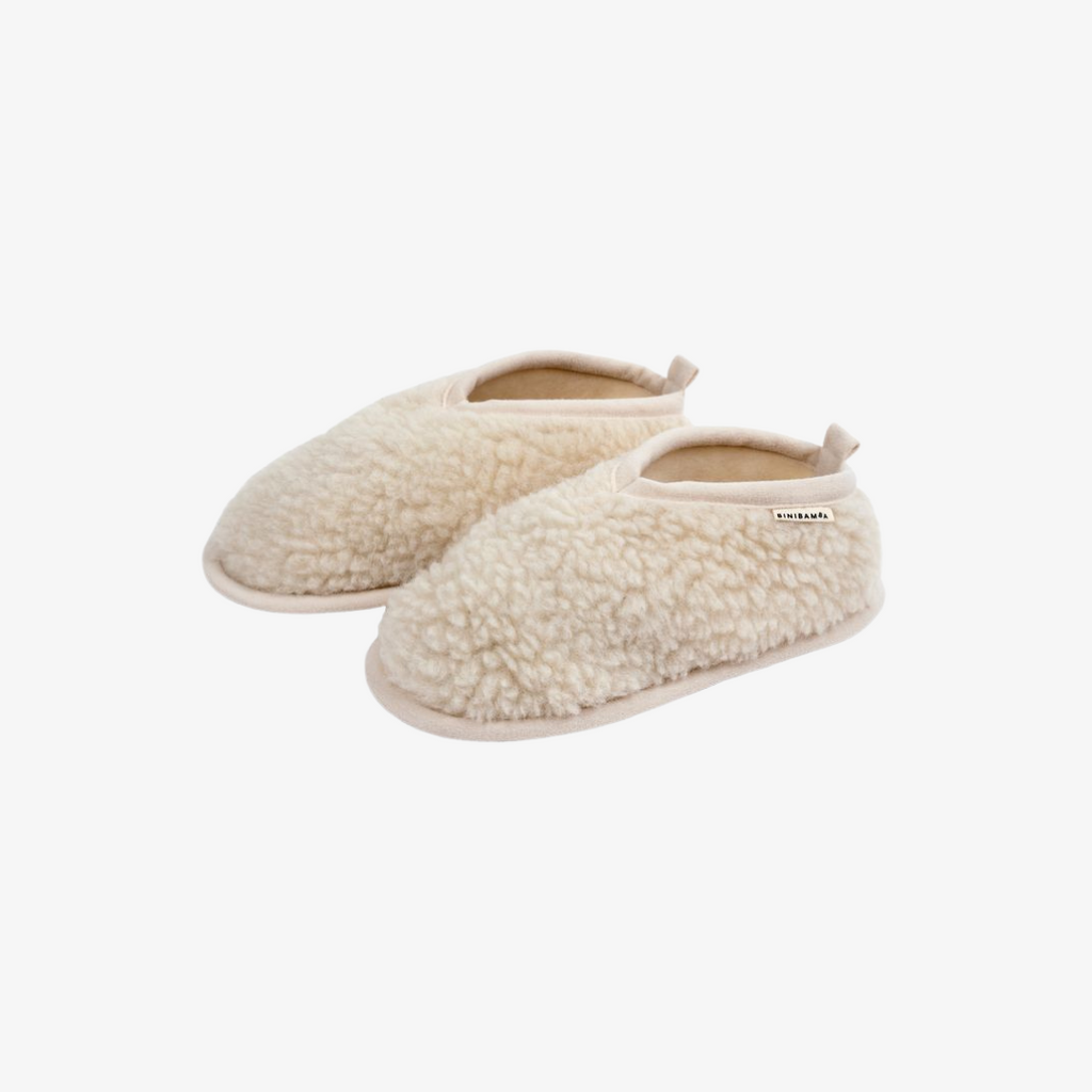 Pair of cream-colored slippers on a white background