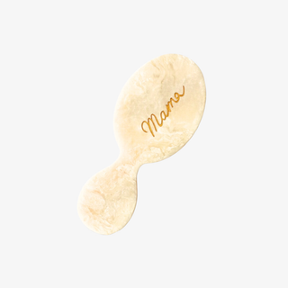 Cream-colored miniature paddle brush with 'Mama' engraving on a light gray background