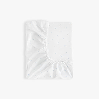 White fitted sheet with blue polka dot pattern on a white background