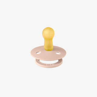 Natural rubber and pink pacifier on a white background
