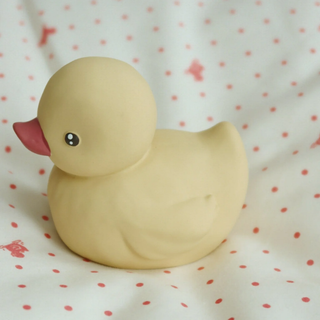 Yellow rubber duck on a white background with red polka dots