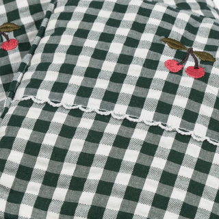 Green and white checkered fabric with embroidered cherries
