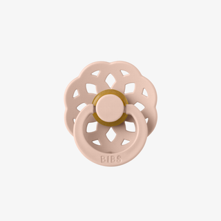 Pink and gold pacifier on a white background