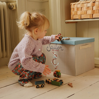 Young girl playing with wooden train. 