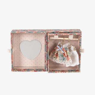 Floral-patterned box with a heart-shaped mirror and baby dress on a white background