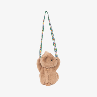 Small brown plush bear with a colorful strap on a white background