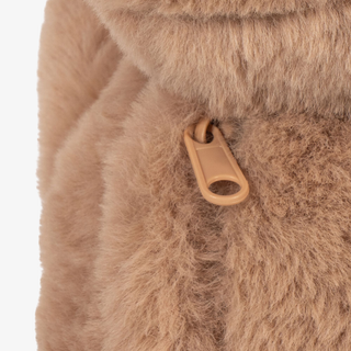 Close-up of a fluffy beige bag with a zipper detail on a white background