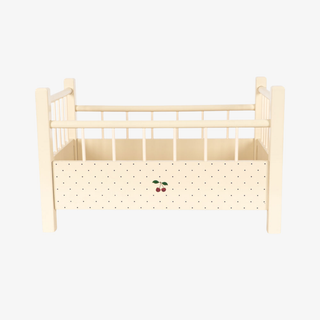 Wooden crib with a polka dot print on a white background