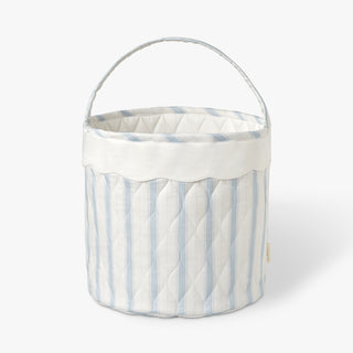 Blue ad white striped quilted basket with handle on while background.
